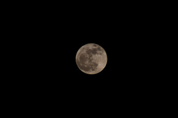 Moon Closeup Showing the Details of Lunar Surface. Cloudy Sky.