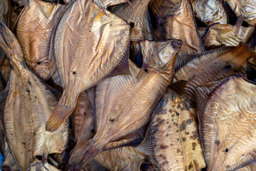 Dried fish on display at a lively market, highlighting local seafood preservation for sale.
