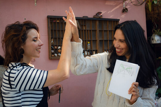 Art teacher congratulates her student for the result of the task during the workshop