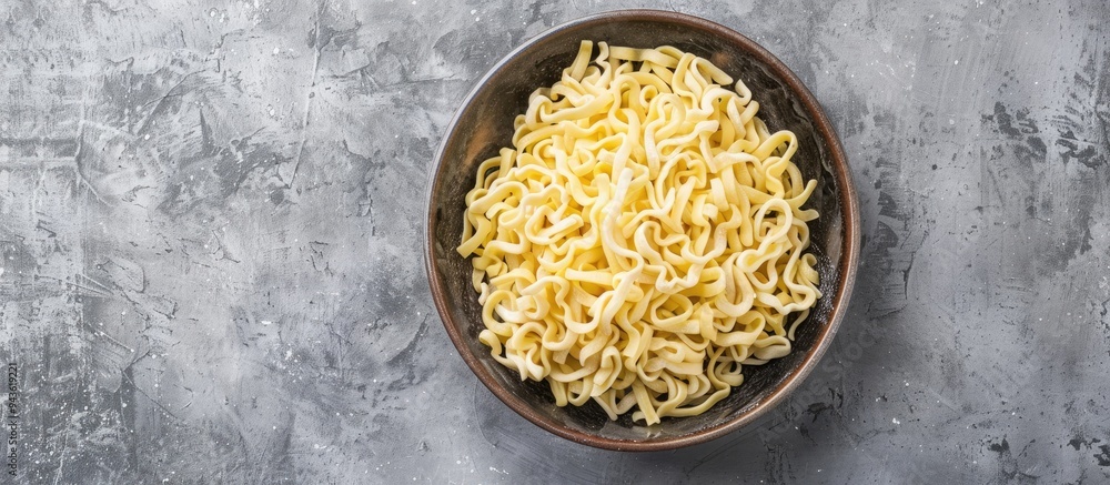 Poster top view of raw dried spaetzle egg noodle on a gray background with copy space image