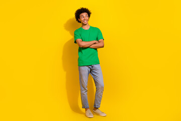 Naklejka premium Full length photo of funky cool guy dressed green t-shirt arms folded emtpy space isolated yellow color background