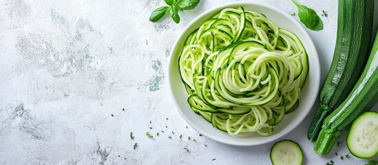 Zucchini vegetable noodles green zoodles or courgette spaghetti served on a plate against a gray background Clean eating raw vegetarian food idea Copy space for text Top view or flat lay