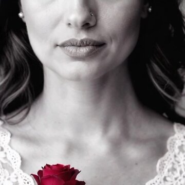 Fotografia art&iacute;stica em preto e branco com destaque para uma rosa vermelha de uma linda mulher.