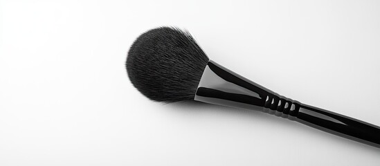 Black handled makeup brush on a white background with copyspace
