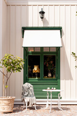 Gemütliche Sitzgruppe vor grünem Fenster. Kleines Kaffee mit Sitzgruppe vor Fenster.
Cozy seating area in front of a green window. Small café with seating area in front of window.