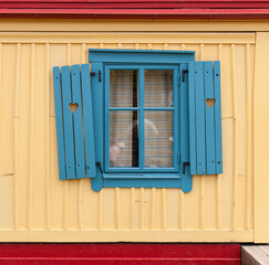 Schiefe blaue Fenster. Lustige Architektur. Herz in Fensterladen. Crooked blue windows. Funny architecture. Heart in shutter.