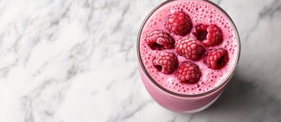 Berries smoothie or raspberry pink red milkshake served in a glass on a bright marble surface Overhead perspective copyspace available Promotion for milkshake cafe menu Coffee shop menu Horizontal im