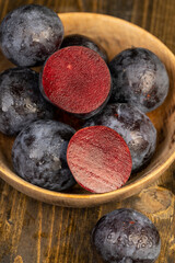 cut purple plums on the table during cooking