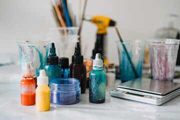 Colorful resin pigments and tools on a worktable, DIY art supplies, creative studio setup, epoxy...