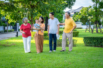 Fototapeta premium Asian family and baby are in the grass. Everyone looks happy.