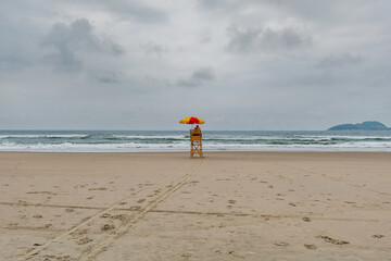 Beach lifeguard in the middle of the beach on a cloudy day and no people on the sea. Tombo beach, Guaruja - SP, Brazil.