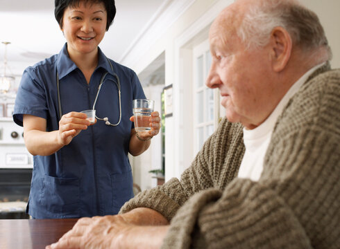 Senior Man Receiving Assistance with Taking Pills
