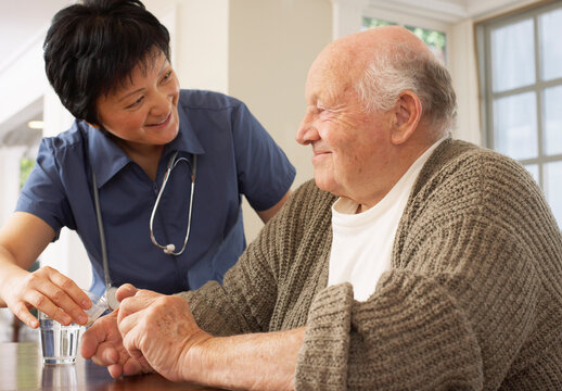 Senior Man Receiving Assistance with Taking Pills