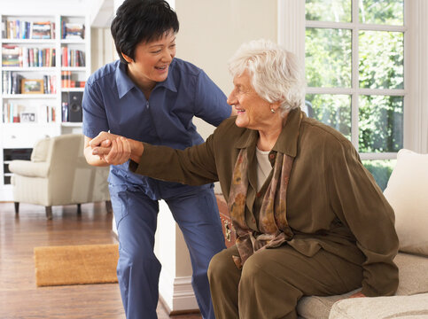 Senior Woman Receiving Assistance with Getting out of Chair