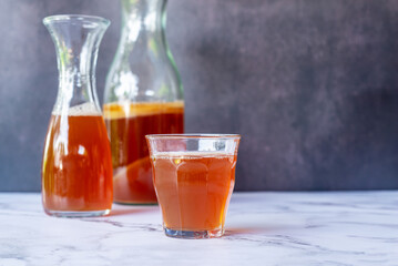 A glass of fermented probiotic tea drink kombucha on marble table background.