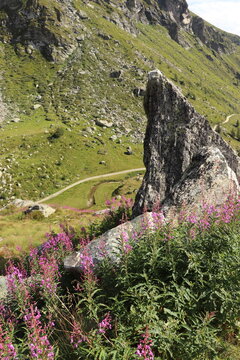 Uno spuntone roccioso aguzzo si erge imponente, dominando un panorama montano mozzafiato.