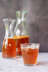 A glass of fermented probiotic tea drink kombucha on marble table background.