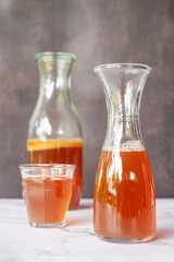  A glass jar of fermented probiotic tea drink kombucha on marble table background.