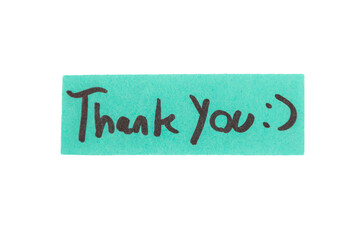 A piece of paper with the words "thank you" written in black. The paper is placed on a white background
