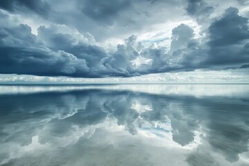 Obraz premium A calm sea reflects the sky, which is overcast with a few breaks in the clouds.