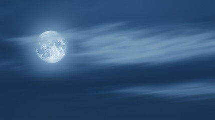 A full moon shines brightly amidst soft clouds in the night sky, creating a serene and tranquil atmosphere of natural beauty.