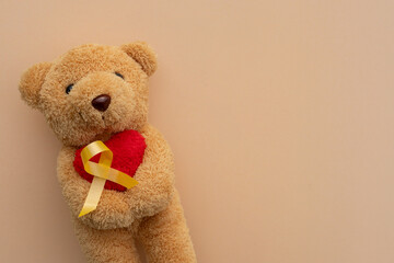 close up cute teddy bear with ribbon on beige background for representative of awareness of...