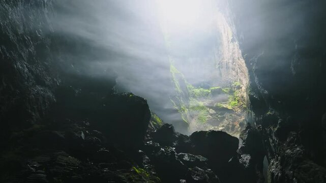 A breathtaking drone shot flying backward through the thick mist at the Doline 1 in Hang Son Doong Cave, Vietnam