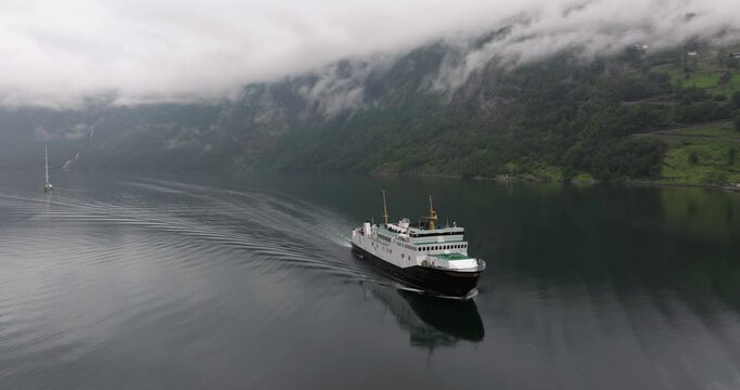 Cinematic Establishing Drone Shot Above Ferry Boat on Overcast Foggy Day. Norway