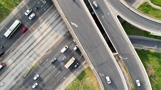 Tr&acirc;nsito de autom&oacute;veis em avenidas e viaduto. Vista de topo feita por drone