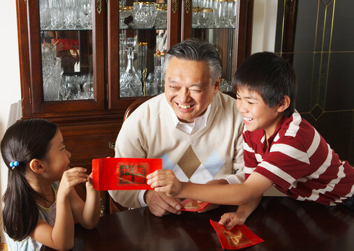 Grandfather with Grandchildren Holding Ang Pow Envelopes