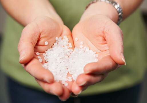 Hands Holding Plastic Polymer Pellets