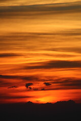 The sun setting behind the clouds. Orange sky. Amazing sunset