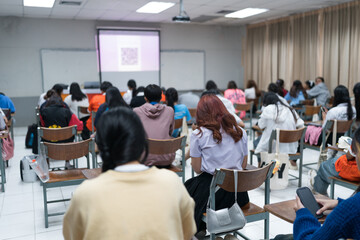 Selective focused high school or university students are intently writing on their answer sheets during a final exam in the classroom.