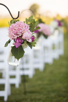 Flowers Hanging at End of Rows of Chairs at Wedding