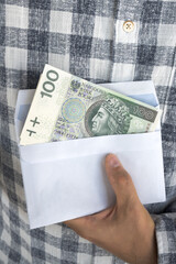 Osoba trzymająca polskie banknoty stuzłotowe.