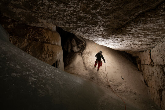 Researcher explores an ice cave in European Alps of Austria
