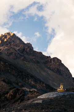 Golden hindu statue sitting in a mountain valley, a religious deity in the Himalayas; Spiti Valley, Himachal Pradesh, India