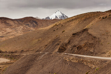Road through the Spiti Valley with a snow-capped mountain in the distance along the Dhar Lung Wooh mountain pass, in the Kaza area of Spiti Valley; Himachal Pradesh, India