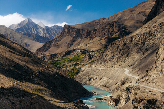 Beautiful landscape with Himalayan mountains and aquamarine river flowing through a valley with a trail on route to Dorzong Buddhist Monastic Institute in Zanskar, Ladakh; Zanskar, Ladakh, India