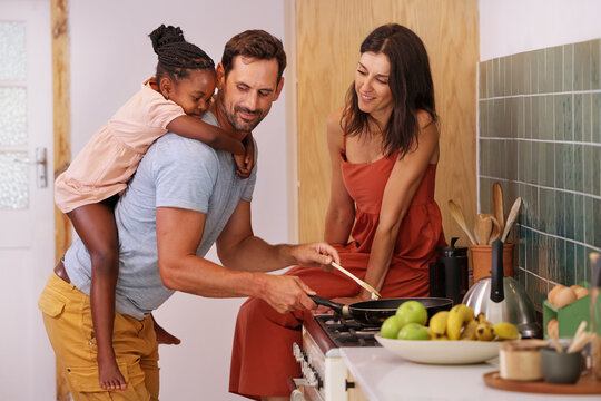 Parents with daughter (6-7) coking in kitchen