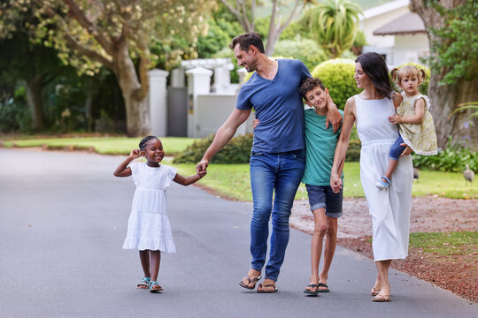 Parents with children (18-22 months, 6-7, 8-9) walking on street