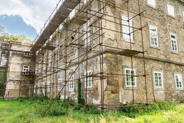 An old building in scaffolding before the start of construction work.