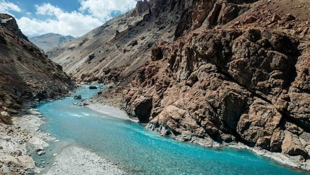 Beautiful aquamarine coloured Tsarap River flowing in a valley with steep rugged mountainsides near Phuktal Gompa (Monastary), near Purne, Zanskar, Ladakh; Zanskar, Ladakh, India