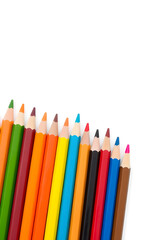 Fototapeta premium A vibrant collection of colored pencils arranged in a row, showcasing a variety of colors including red, blue, green, yellow, and orange against a white background.