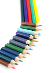 Fototapeta premium A vibrant collection of colored pencils arranged in a row, showcasing a variety of colors including red, blue, green, yellow, and orange against a white background.