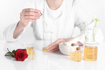 Aromatherapy product. Scientist developing essential oils at white table in laboratory, closeup