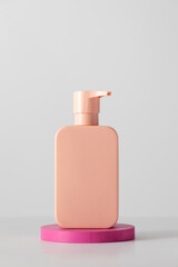 A pink mock-up of a cosmetic product with a place for a logo on the podium. 