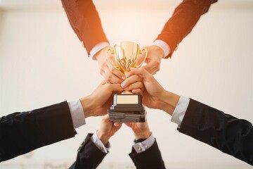 Collaboration Catalyzes Success: A Visual Representation of Teamwork. The hand of a business man and business women pick up the trophy and celebrate together