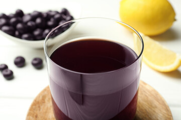 Delicious acai juice in glass on white table, closeup