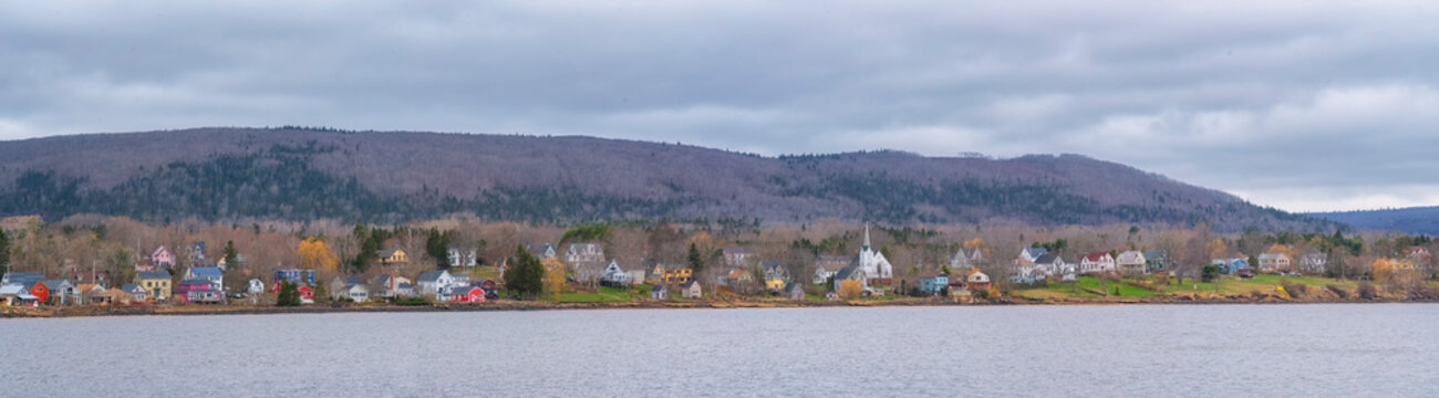 View across from Annapolis Royal on a moody spring day, Nova Scotia. Multi coloured homes dot the landscape; Annapolis Royal, Nova Scotia, Canada